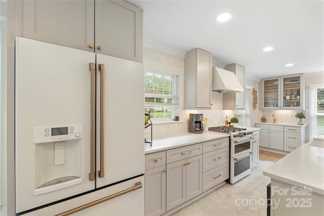 4201 Tyndale Ave, Charlotte, NC 28210 - kitchen with white appliances, custom range hood, backsplash, light countertops, and glass insert cabinets