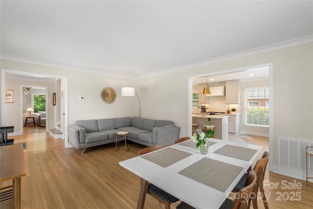 4201 Tyndale Ave, Charlotte, NC 28210 - dining room with crown molding, light wood-style flooring, and plenty of natural light