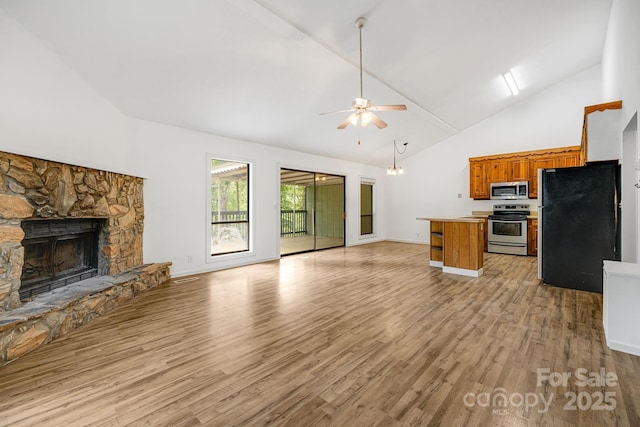 263 Shannons Walk, Lake Lure, NC 28746 - kitchen with appliances with stainless steel finishes, open floor plan, brown cabinetry, a fireplace, and a ceiling fan