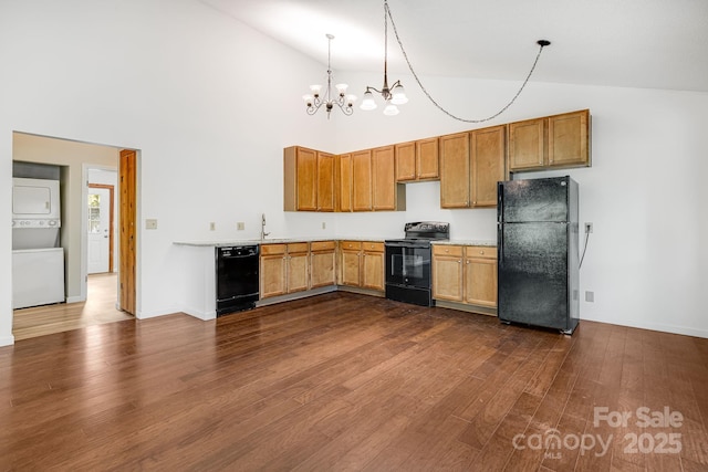 263 Shannons Walk, Lake Lure, NC 28746 - kitchen featuring black appliances, stacked washing machine and dryer, light countertops, dark wood-style floors, and high vaulted ceiling
