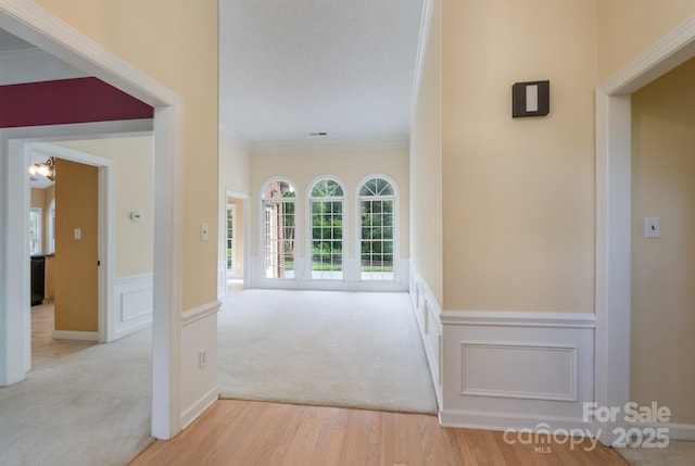 10511 Pullengreen Dr, Charlotte, NC 28277 - hallway with crown molding, wood finished floors, a wainscoted wall, and carpet flooring