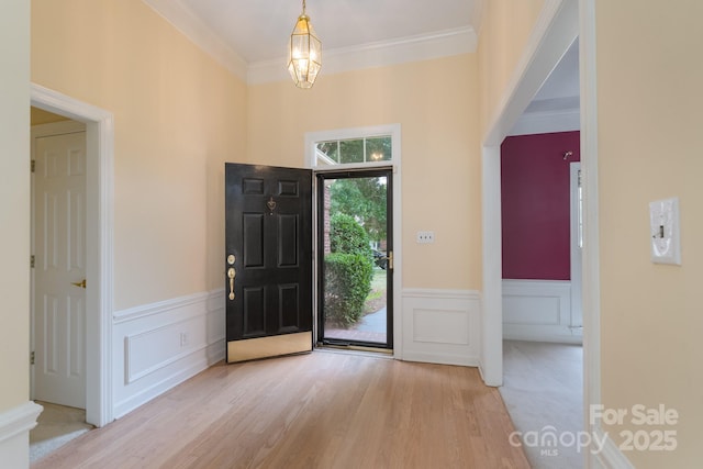 10511 Pullengreen Dr, Charlotte, NC 28277 - entryway featuring wood finished floors, a wainscoted wall, a decorative wall, crown molding, and a chandelier
