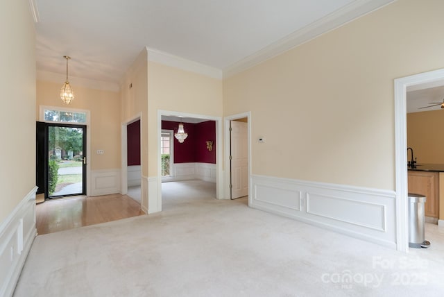 10511 Pullengreen Dr, Charlotte, NC 28277 - carpeted foyer with crown molding, wainscoting, a decorative wall, and a chandelier