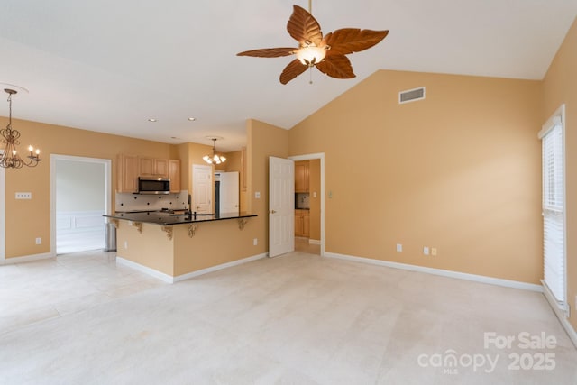 10511 Pullengreen Dr, Charlotte, NC 28277 - kitchen with a chandelier, stainless steel microwave, a kitchen breakfast bar, dark countertops, and a ceiling fan