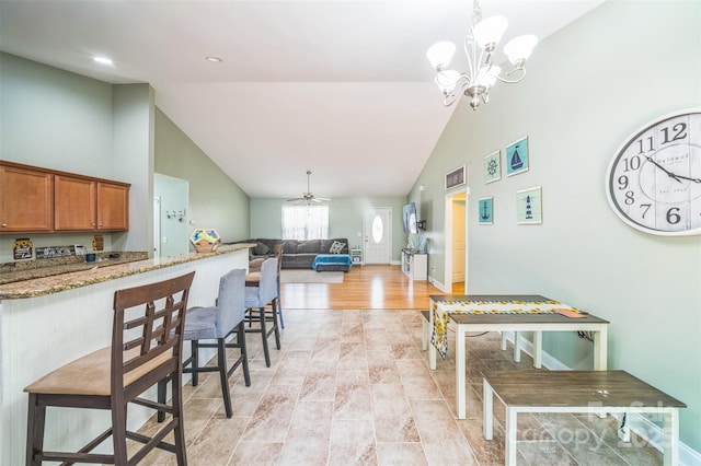 239 Shellbank Dr, Sneads Ferry, NC 28460 - kitchen featuring high vaulted ceiling, brown cabinetry, light stone counters, pendant lighting, and ceiling fan