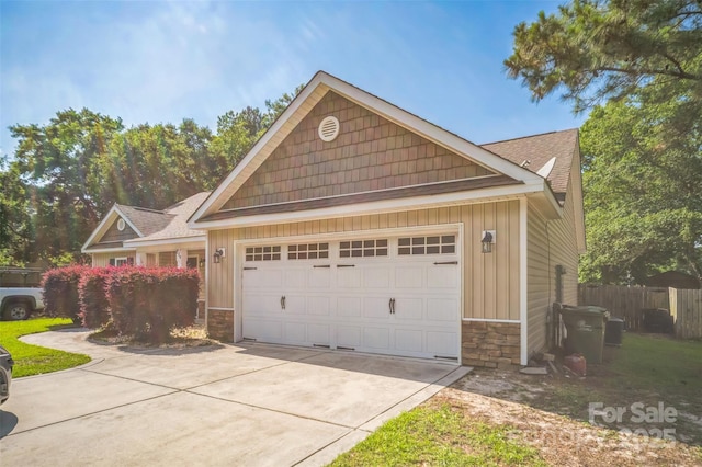 239 Shellbank Dr, Sneads Ferry, NC 28460 - view of front of house with stone siding, driveway, a garage, and board and batten siding