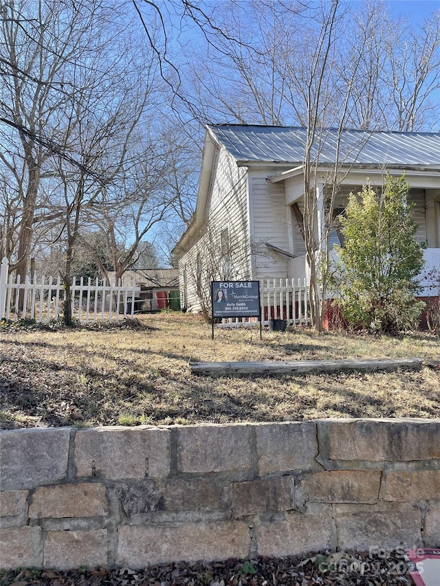 121 W Centerview St, China Grove, NC 28023 - view of property exterior featuring a metal roof and a fenced front yard
