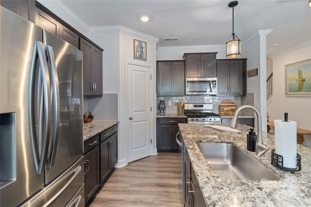 1076 Chicory Trce, Clover, SC 29710 - kitchen with stainless steel appliances, light wood-type flooring, ornamental molding, backsplash, and decorative light fixtures