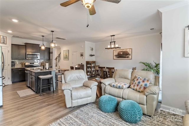 1076 Chicory Trce, Clover, SC 29710 - living room featuring light wood-style floors, crown molding, a ceiling fan, recessed lighting, and a chandelier