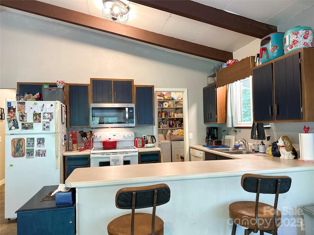 171 Windy Hill Dr, Franklin, NC 28734 - kitchen featuring white appliances, washer and dryer, a peninsula, a breakfast bar, and light countertops