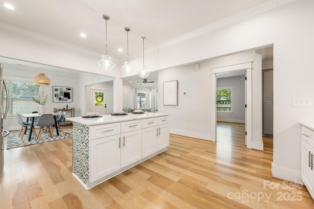 5305 Tarrywood Ln, Charlotte, NC 28205 - kitchen featuring light wood finished floors, white cabinetry, healthy amount of natural light, light countertops, and crown molding