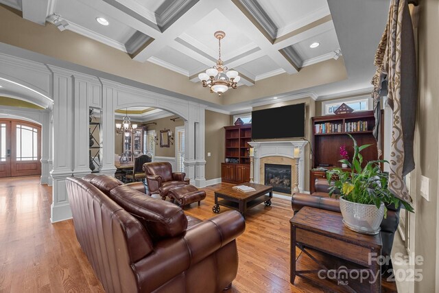 3211 Keady Mill Loop, Kannapolis, NC 28081 - living area featuring a chandelier, arched walkways, crown molding, decorative columns, and light wood-style floors