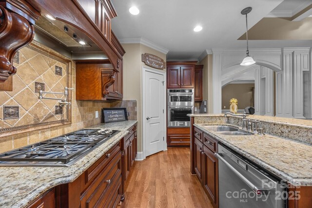 3211 Keady Mill Loop, Kannapolis, NC 28081 - kitchen featuring appliances with stainless steel finishes, arched walkways, light stone counters, backsplash, and hanging light fixtures