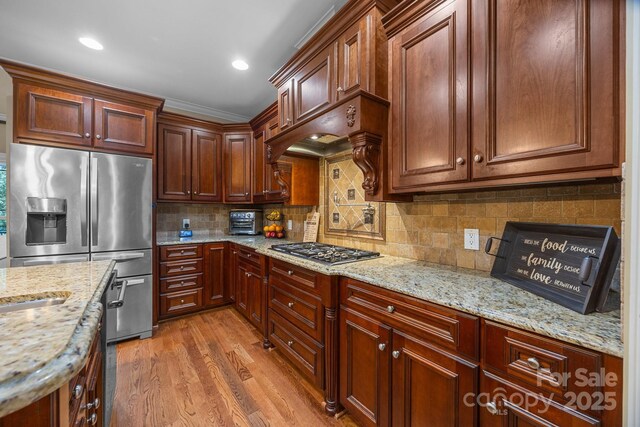 3211 Keady Mill Loop, Kannapolis, NC 28081 - kitchen featuring stainless steel appliances, light wood-style floors, light stone countertops, decorative backsplash, and arched walkways