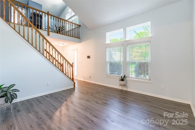 8909 Raven Park Dr, Charlotte, NC 28216 - unfurnished living room with stairway, plenty of natural light, wood finished floors, and high vaulted ceiling