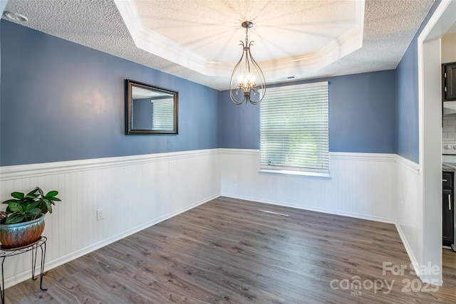 8909 Raven Park Dr, Charlotte, NC 28216 - unfurnished room with a raised ceiling, a textured ceiling, wainscoting, wood finished floors, and a chandelier