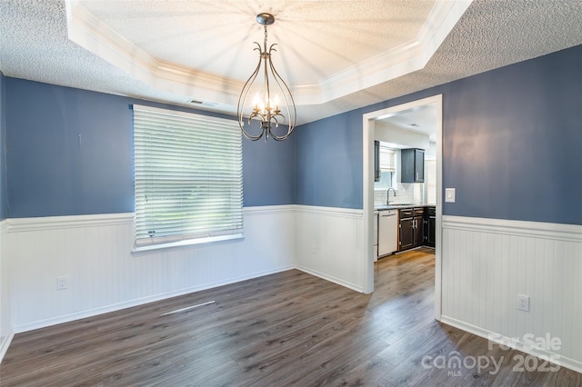 8909 Raven Park Dr, Charlotte, NC 28216 - unfurnished dining area featuring wainscoting, a chandelier, a textured ceiling, crown molding, and a tray ceiling
