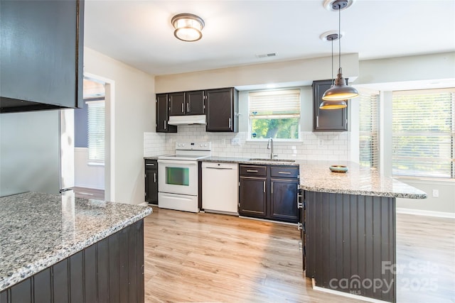 8909 Raven Park Dr, Charlotte, NC 28216 - kitchen featuring white appliances, light wood-style floors, a peninsula, backsplash, and light stone countertops