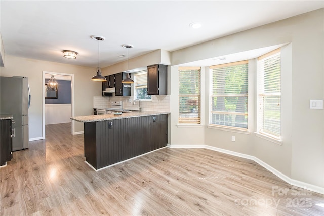 8909 Raven Park Dr, Charlotte, NC 28216 - kitchen featuring freestanding refrigerator, a peninsula, white electric range, tasteful backsplash, and ventilation hood