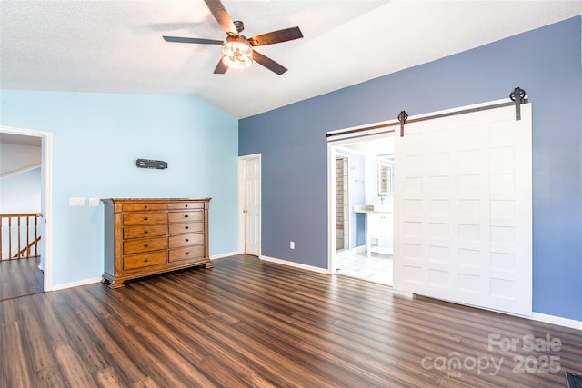 8909 Raven Park Dr, Charlotte, NC 28216 - unfurnished bedroom featuring wood finished floors, vaulted ceiling, a barn door, and ceiling fan