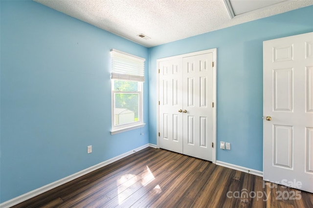8909 Raven Park Dr, Charlotte, NC 28216 - unfurnished bedroom with a closet, dark wood-style floors, and a textured ceiling