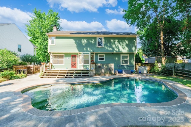 8909 Raven Park Dr, Charlotte, NC 28216 - rear view of house with a chimney, a wooden deck, and a patio area