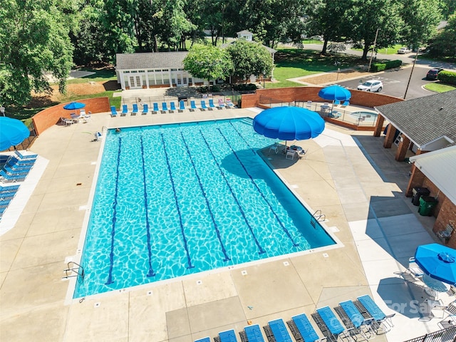 8909 Raven Park Dr, Charlotte, NC 28216 - community pool with a patio area and view of wooded area
