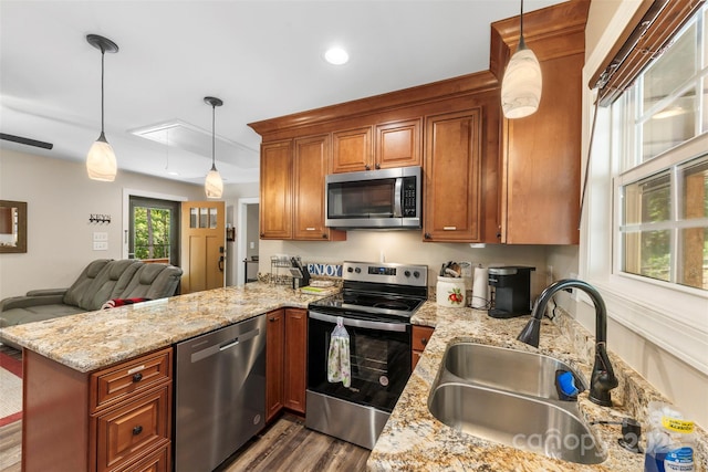 8333 Catawba Cove Dr, Belmont, NC 28012 - kitchen with stainless steel appliances, a peninsula, brown cabinets, dark wood-type flooring, and light stone counters