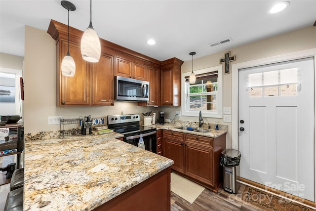 8333 Catawba Cove Dr, Belmont, NC 28012 - kitchen with appliances with stainless steel finishes, wood finished floors, light stone counters, recessed lighting, and brown cabinets
