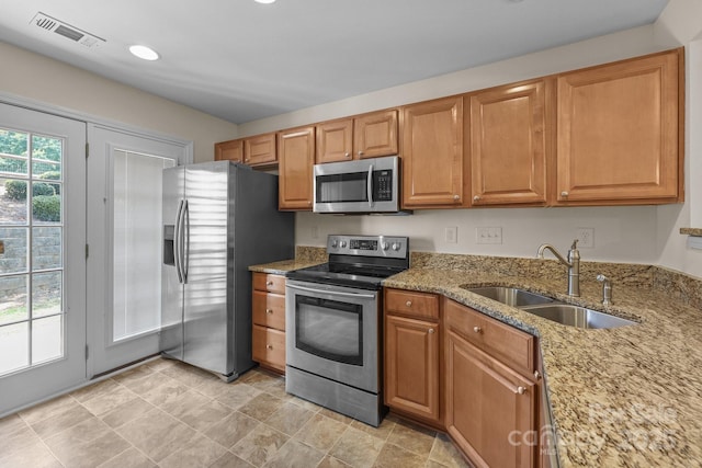 348 Tidmarsh Ct NW, Concord, NC 28027 - kitchen featuring appliances with stainless steel finishes, light stone counters, brown cabinetry, and recessed lighting