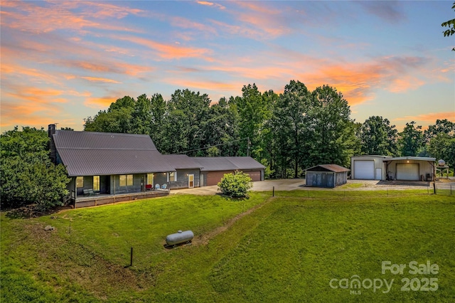 144 J And W Rd, Olin, NC 28660 - view of front facade featuring driveway, a yard, a detached garage, a porch, and a metal roof