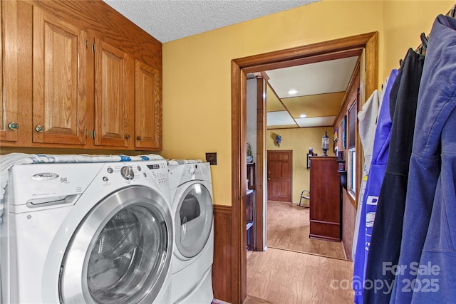 144 J And W Rd, Olin, NC 28660 - laundry area with independent washer and dryer, cabinet space, light wood finished floors, a textured ceiling, and a wainscoted wall