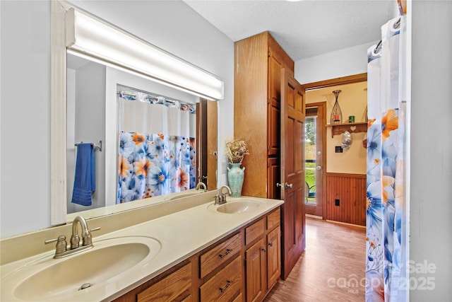 144 J And W Rd, Olin, NC 28660 - bathroom featuring double vanity, wood finished floors, a wainscoted wall, wooden walls, and a textured ceiling