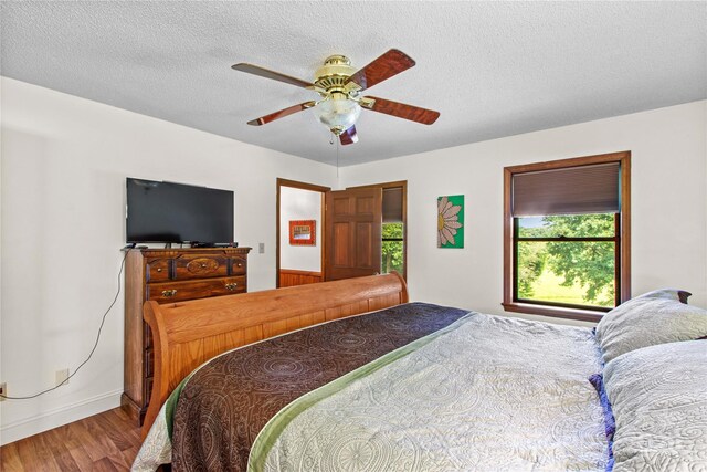 144 J And W Rd, Olin, NC 28660 - bedroom with wood finished floors, a ceiling fan, and a textured ceiling