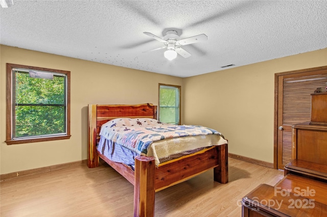 144 J And W Rd, Olin, NC 28660 - bedroom featuring light wood-style flooring, a textured ceiling, and a ceiling fan