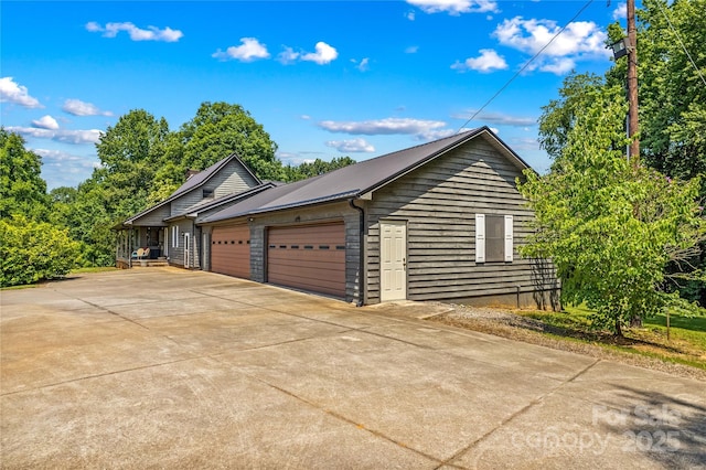 144 J And W Rd, Olin, NC 28660 - view of property exterior featuring an attached garage, a metal roof, and concrete driveway