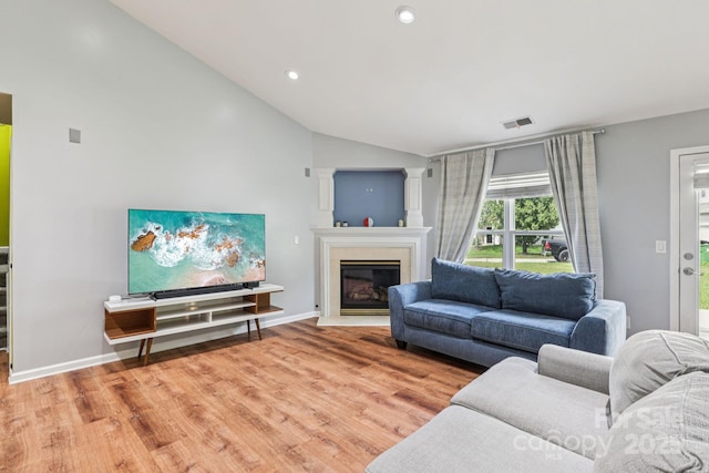 16009 Stuarts Draft Ct, Charlotte, NC 28278 - living room featuring vaulted ceiling, light wood-style flooring, a glass covered fireplace, and recessed lighting