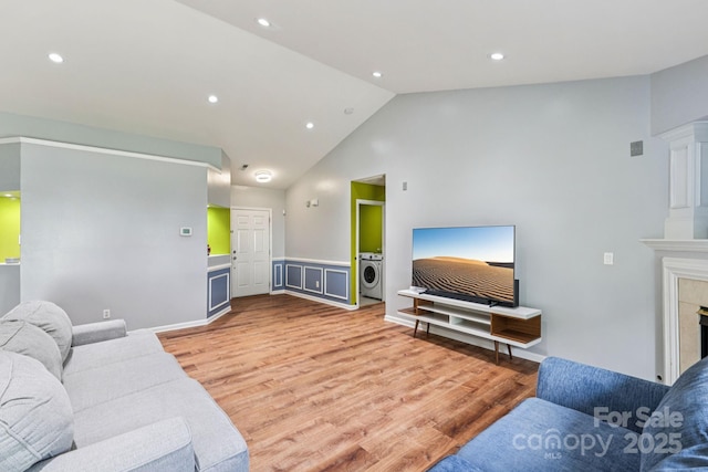 16009 Stuarts Draft Ct, Charlotte, NC 28278 - living room featuring washer / dryer, recessed lighting, wood finished floors, high vaulted ceiling, and a fireplace