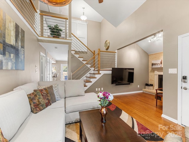 9237 N Vicksburg Park Ct, Charlotte, NC 28210 - living room featuring wood finished floors, stairway, a large fireplace, and a high ceiling
