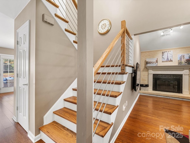 9237 N Vicksburg Park Ct, Charlotte, NC 28210 - stairs with wood finished floors and a glass covered fireplace