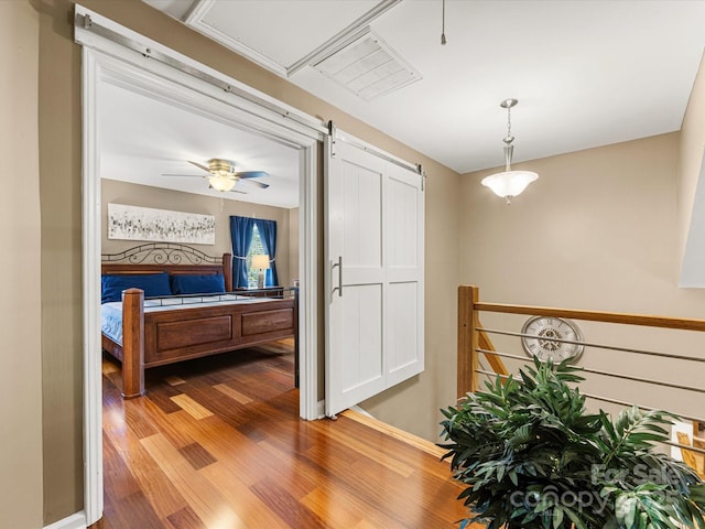 9237 N Vicksburg Park Ct, Charlotte, NC 28210 - corridor with wood finished floors, a barn door, and an upstairs landing