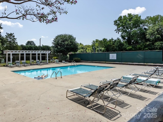 9237 N Vicksburg Park Ct, Charlotte, NC 28210 - community pool featuring a patio and view of wooded area