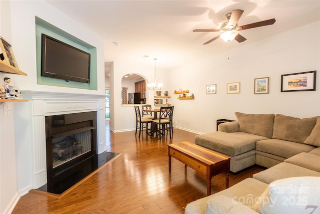 141 Leyton Loop Unit B, Mooresville, NC 28117 - living area featuring arched walkways, wood finished floors, a fireplace with raised hearth, a ceiling fan, and a chandelier
