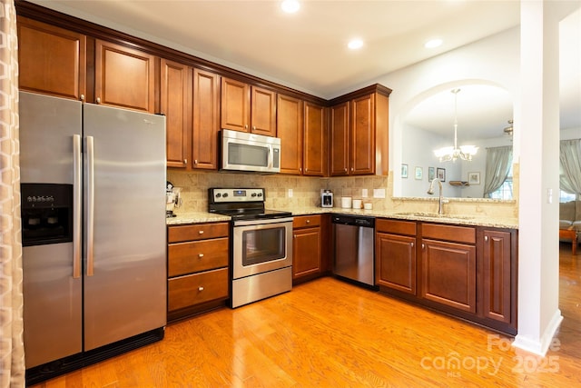 141 Leyton Loop Unit B, Mooresville, NC 28117 - kitchen featuring stainless steel appliances, a chandelier, light wood-type flooring, decorative backsplash, and recessed lighting