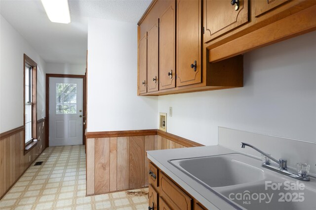 621 Big Lick Rd, Oakboro, NC 28129 - kitchen featuring light floors, wainscoting, brown cabinets, and light countertops