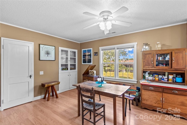 179 J And W Rd, Olin, NC 28660 - dining area featuring a textured ceiling, light wood-type flooring, ceiling fan, and crown molding