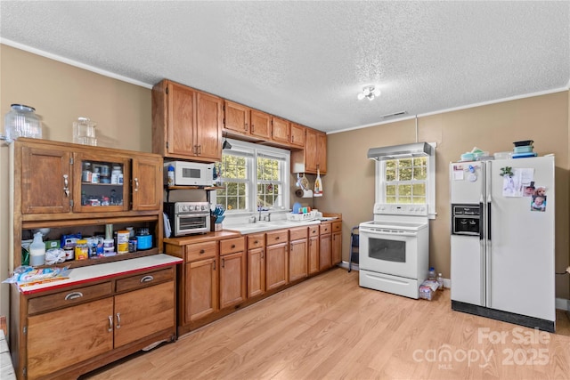 179 J And W Rd, Olin, NC 28660 - kitchen featuring white appliances, light wood-style flooring, brown cabinets, a textured ceiling, and light countertops