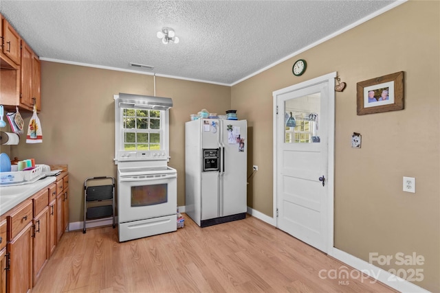 179 J And W Rd, Olin, NC 28660 - kitchen with white appliances, a textured ceiling, light wood finished floors, brown cabinetry, and light countertops