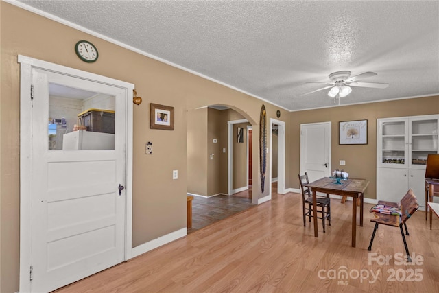 179 J And W Rd, Olin, NC 28660 - dining space with arched walkways, a textured ceiling, ceiling fan, wood finished floors, and crown molding