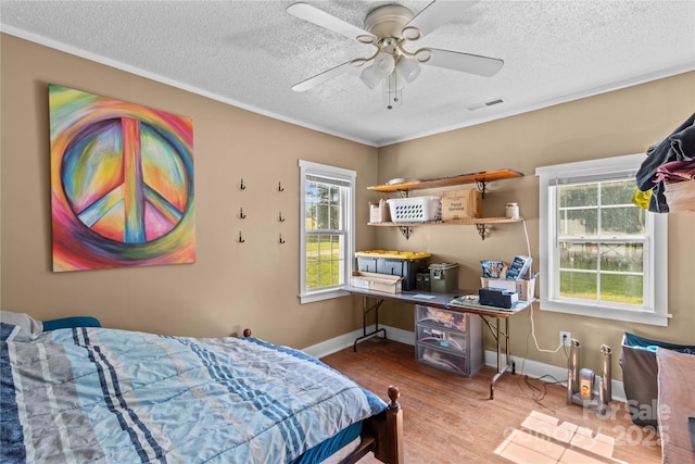 179 J And W Rd, Olin, NC 28660 - bedroom featuring wood finished floors, a textured ceiling, multiple windows, and ceiling fan